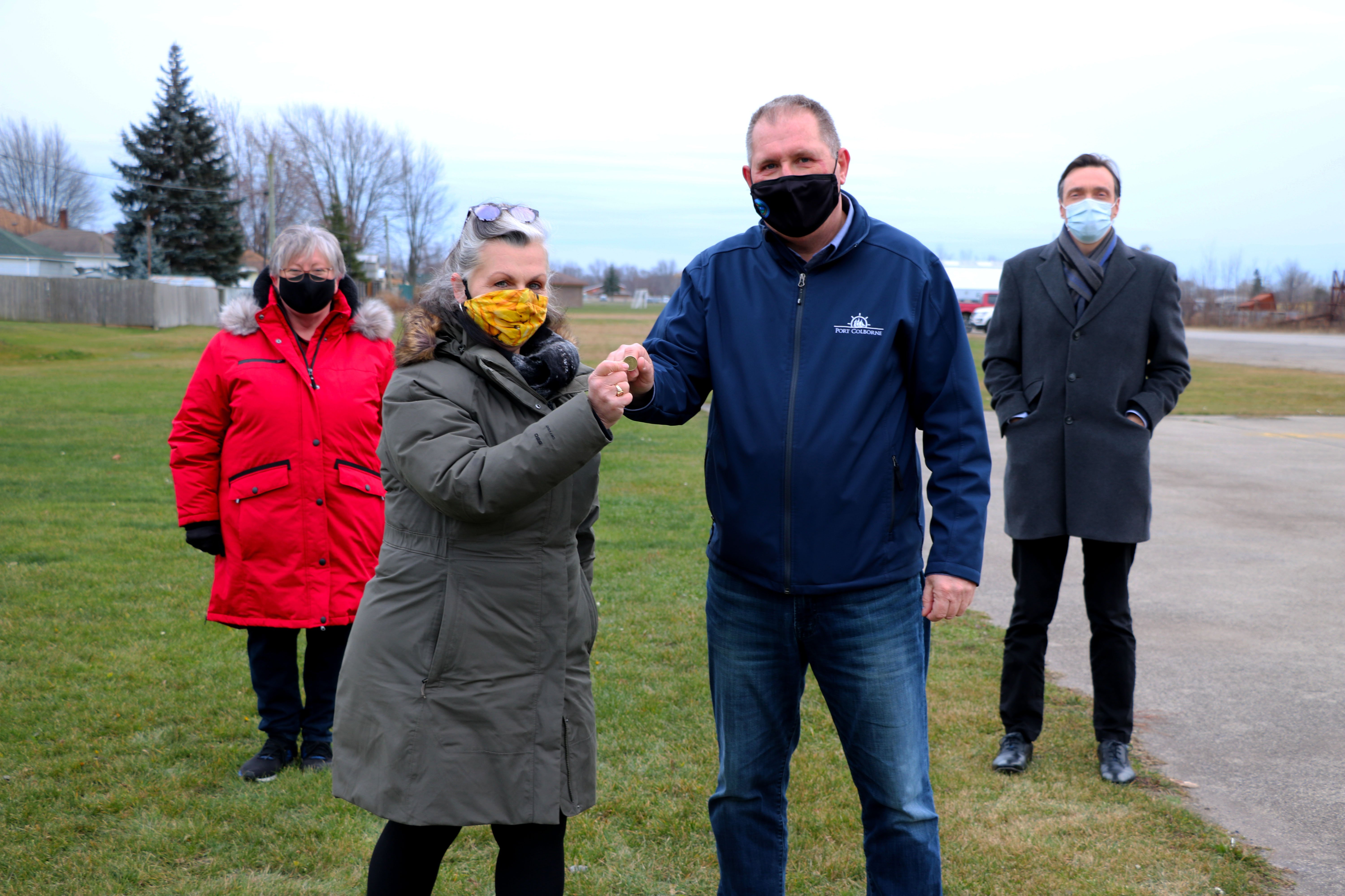 Port Cares Executive Director, Christine Clark Lafleur hands Mayor Bill Steele a loonie to symbolize the City transferring Chestnut Park to #PortCares for $1 loonie to symbolize 